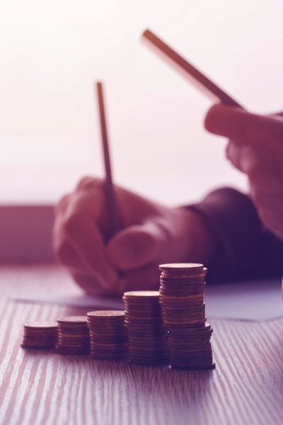 Savings, finances, economy and home budget calculations. Close up of man doing calculations and writing notes at home.